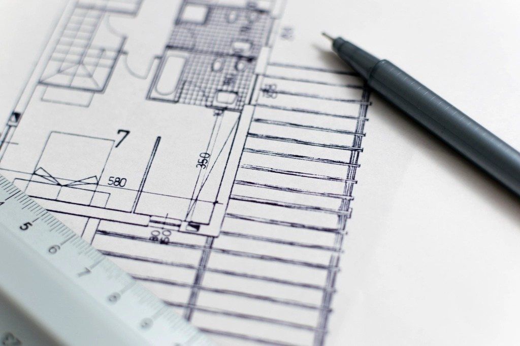 Architect drawing a floor plan with a pencil