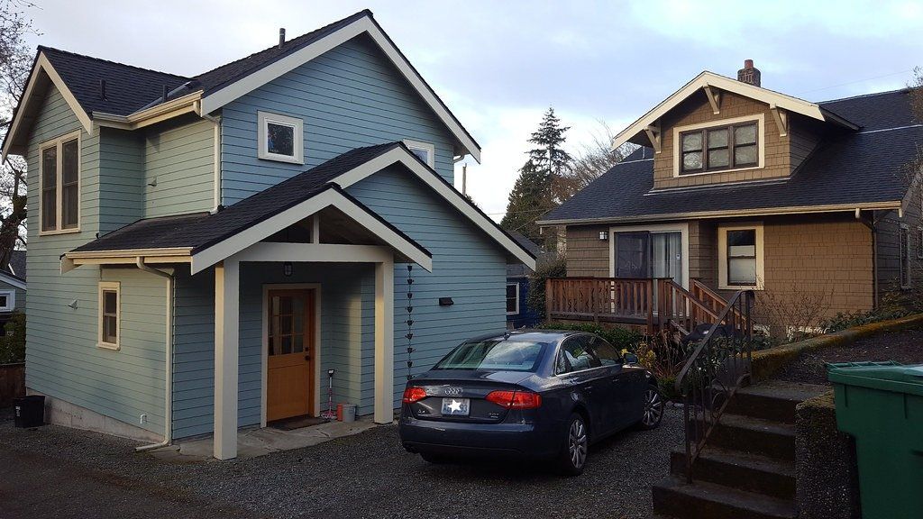 Detached backyard cottage behind a two-story house