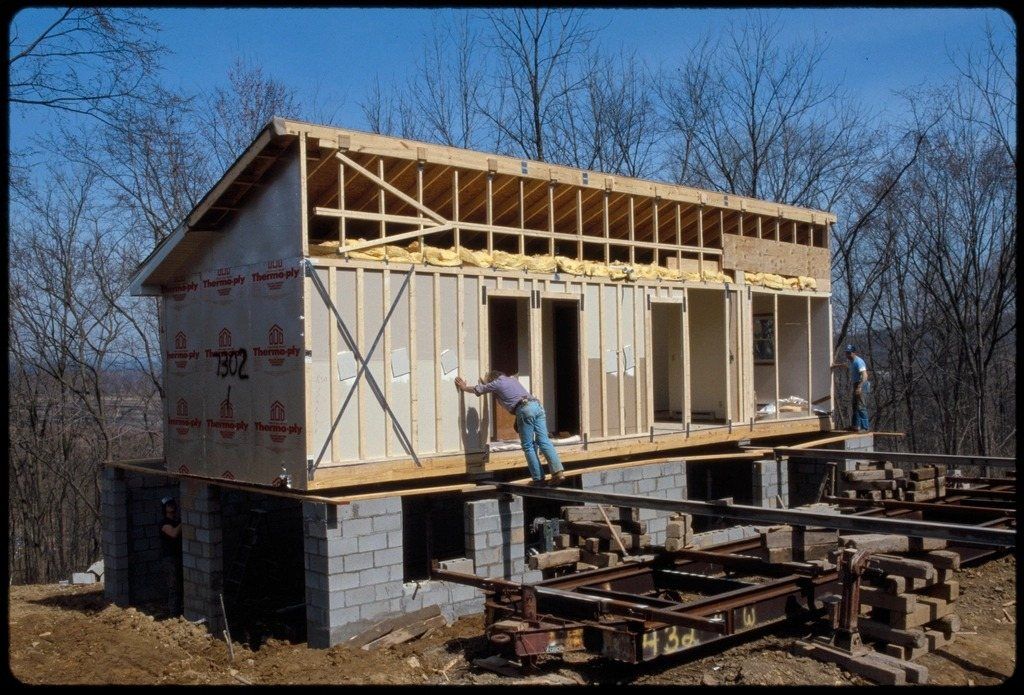 Modular house sections being assembled on a foundation